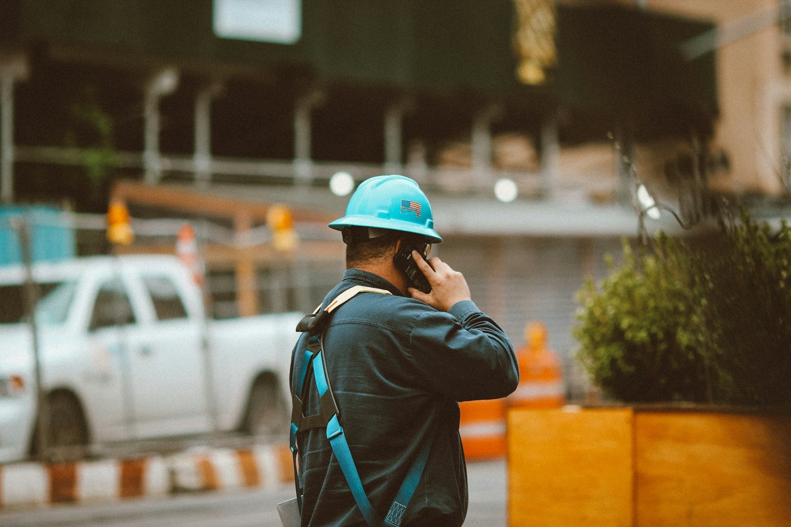 Contractor in a hard hat taking a phone call on a job site
