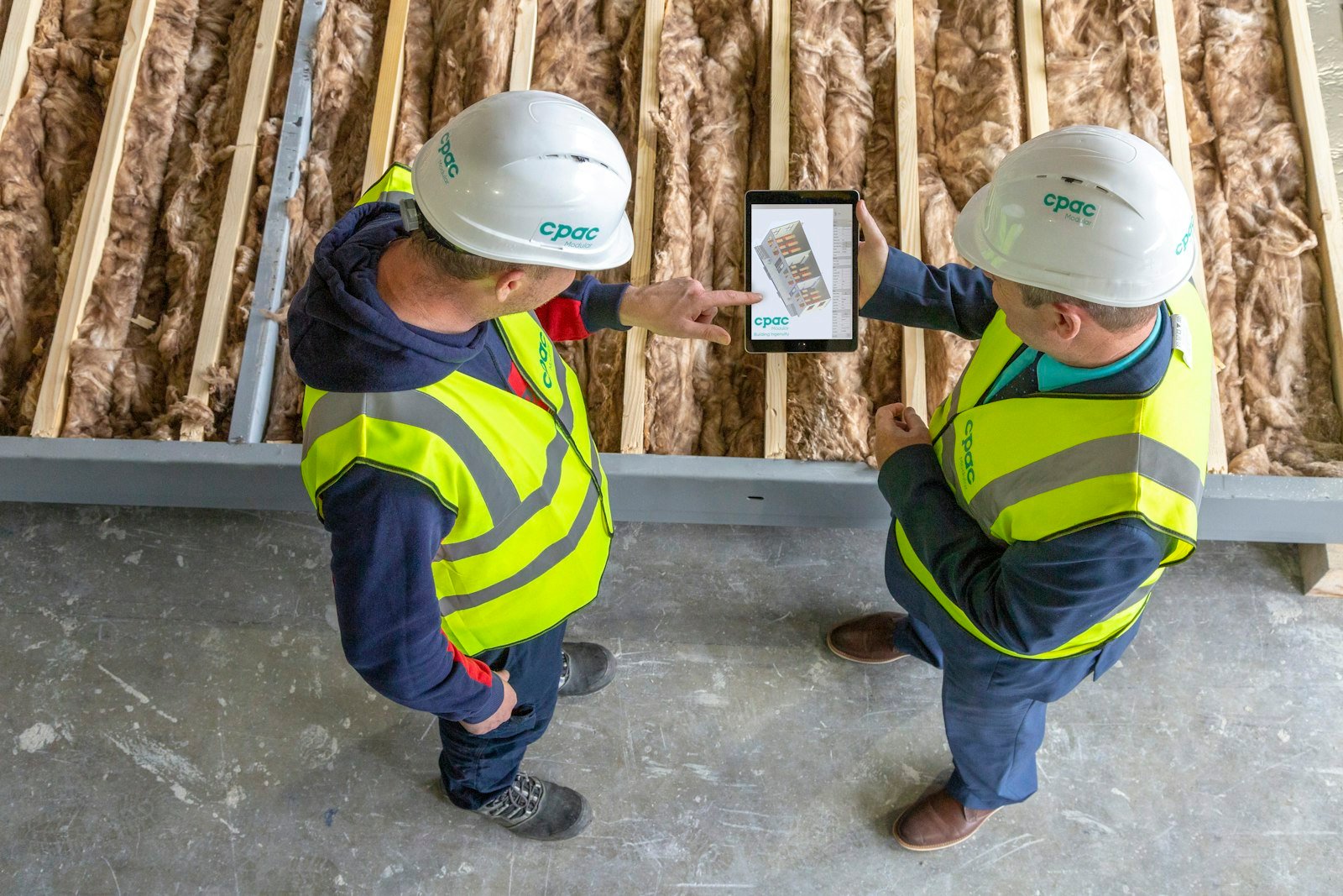 Two contractors reviewing plans on a tablet
