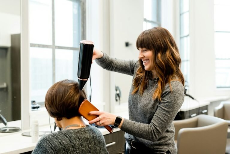 Hair stylist blow-drying a client's hair in a salon
