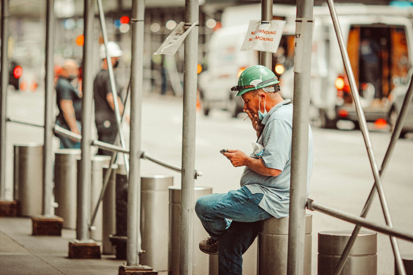 Tradesperson checking his phone on a job site